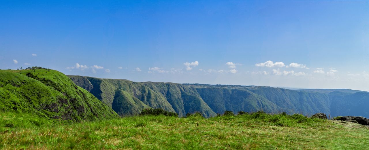 Stunning panoramic view of Meghalaya's lush green hill ranges under a clear blue sky.
